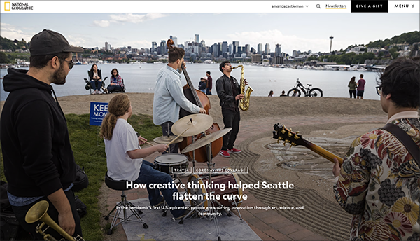 An image from a National Geographic article showing musicians playing atop a hill with Lake Union and the Seattle Skyline in the background